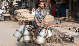 A man delivers pails of fresh milk to customers in rural India
